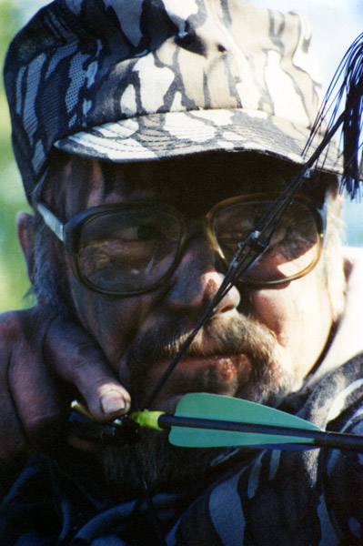 Close up of Dr. Ken Nordberg with bow at full draw.